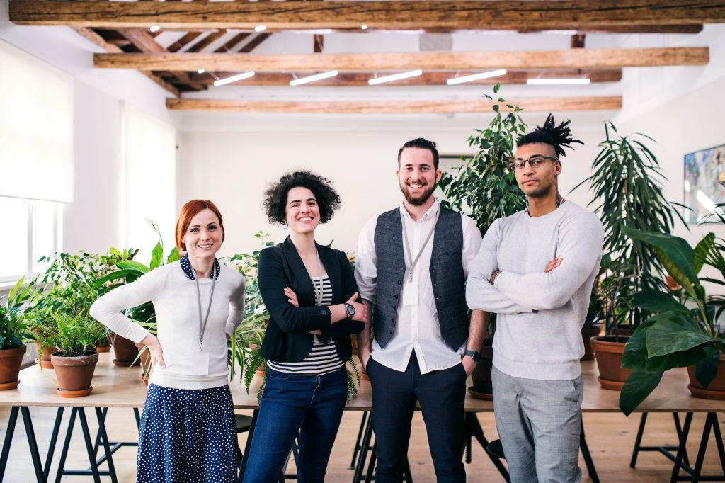 Group of young businesspeople standing in office, looking at camera